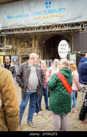 La guida ufficiale del tour a piedi di Canterbury si trova all'esterno della cattedrale di Canterbury con un gruppo di turisti. Foto Stock