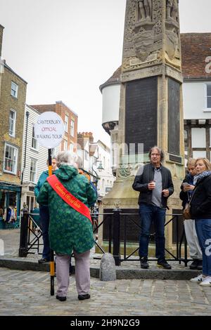 La guida ufficiale del tour a piedi di Canterbury parla a gruppi di turisti con il monumento commemorativo della guerra a Canterbury, Kent. Foto Stock