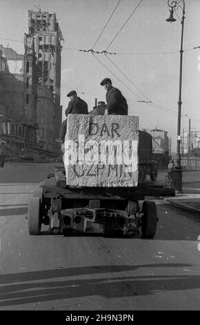 Warszawa, 1948-10-20. Zniszczona w styczniu 1945 r. Kolumna Zygmunta III Wazy zosta³a odbudowana z inicjatywy pracowników Pañstwowych Kamienio³omów. Trzon kolumny wykuto z 30-tonowego bloku granitowego o d³ugoœci 10 metrów, wydobytego w kamienio³omie ¯bik w Strzegomiu i przewiezonego kolej¹ do Warszawy. Dalej transport odbywa³ siê na specjalnej lawecie, której obs³ugê stanowili robotnicy firmy C. Hartwig: Zaj¹c, Glinka, Janke, Czy¿ewski, Dembowski, Wnuk i Kisiel. NZ. Kolumna transportowa na placu Napoleona (Powstañców Warszawy). Z lewej wypalony budynek Towarzystwa Ubezpieczeñ Prudential. pw Foto Stock