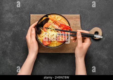 Donna che mangia gustosa zuppa tailandese da ciotola Foto Stock