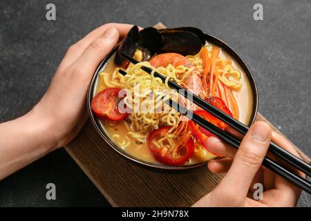 Donna che mangia gustosa zuppa tailandese da ciotola Foto Stock