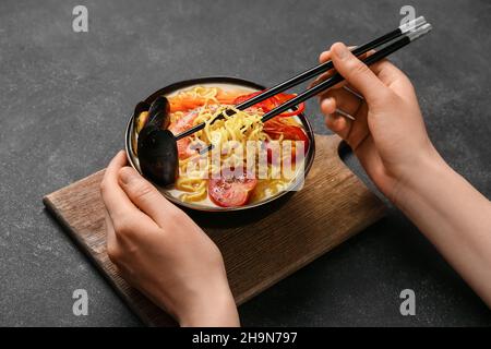 Donna che mangia gustosa zuppa tailandese da ciotola Foto Stock