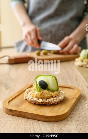 Cracker di riso con delizioso hummus sul tavolo, primo piano Foto Stock