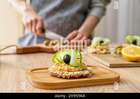 Cracker di riso con delizioso hummus sul tavolo, primo piano Foto Stock