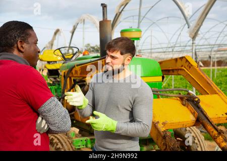 Giovane agricoltore che ha una conversazione spiacevole con il lavoratore Foto Stock