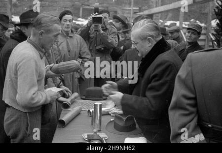 Warszawa, 1948-11-27. Uroczystoœæ wmurowania aktu erekcyjnego w fundenty gmachu Powszechnego Domu Towarowego, w obramowaniu ulic al. Jerozolimskie, Bracka, Krucza. nz. ministro przemys³u i handlu Hilary MiNC (2P) rozmawia z jednym z robotników ekipy budowlanej. W g³êbi operator Polskiej Kroniki Filmowej Karol Szczeciñski (z kamer¹). uu PAP Varsavia, 27 novembre 1948. La cerimonia di posa della fondazione sotto il magazzino PDT situato tra Jerozolimskie Avenue, Bracka Street e Krucza Street. Nella foto: Il ministro dell'industria e del Commercio Hilary MiNC (2nd a destra) parla con un lavoro di costruzione Foto Stock