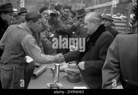 Warszawa, 1948-11-27. Uroczystoœæ wmurowania aktu erekcyjnego w fundenty gmachu Powszechnego Domu Towarowego, w obramowaniu ulic al. Jerozolimskie, Bracka, Krucza. nz. ministro przemys³u i handlu Hilary MiNC (2P) rozmawia z jednym z robotników ekipy budowlanej. W g³êbi operator Polskiej Kroniki Filmowej Karol Szczeciñski (z kamer¹). uu PAP Varsavia, 27 novembre 1948. La cerimonia di posa della fondazione sotto il magazzino PDT situato tra Jerozolimskie Avenue, Bracka Street e Krucza Street. Nella foto: Il ministro dell'industria e del Commercio Hilary MiNC (2nd a destra) parla con un lavoro di costruzione Foto Stock