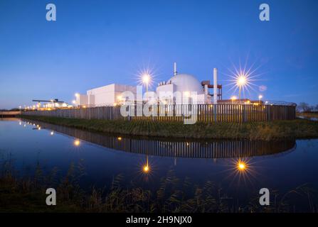 02 dicembre 2021, Schleswig-Holstein, Brokdorf: La centrale nucleare di Brokdorf è circondata da una recinzione e da un fossato (effetto fascio dovuto al lungo tempo di esposizione). Dopo quasi 35 anni di attività, la centrale nucleare sarà chiusa dall'operatore Preussen Elektra alla fine del 2021. Il reattore ad acqua pressurizzata con una potenza di circa 1400 megawatt ha fornito elettricità dal 1986. Foto: Christian Charisius/dpa Foto Stock