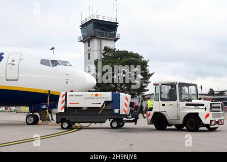 PRODUZIONE - 06 dicembre 2021, Baden-Wuerttemberg, Rheinmünster: Un velivolo Ryanair Boeing 737-800 si trova di fronte alla torre dell'aeroporto di Karlsruhe/Baden-Baden. Prima il cambiamento climatico, poi Corona: Gli aeroporti regionali stanno attualmente avendo difficoltà. (A dpa 'solo un aeroporto per il paese? Aeroporti regionali sotto pressione') Foto: Uli Deck/dpa Foto Stock