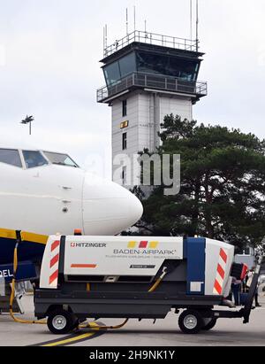 PRODUZIONE - 06 dicembre 2021, Baden-Wuerttemberg, Rheinmünster: Un velivolo Ryanair Boeing 737-800 si trova di fronte alla torre dell'aeroporto di Karlsruhe/Baden-Baden. Prima il cambiamento climatico, poi Corona: Gli aeroporti regionali stanno attualmente avendo difficoltà. (A dpa 'solo un aeroporto per il paese? Aeroporti regionali sotto pressione') Foto: Uli Deck/dpa Foto Stock