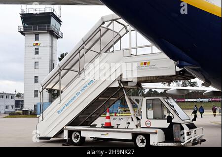 PRODUZIONE - 06 dicembre 2021, Baden-Wuerttemberg, Rheinmünster: Davanti alla torre dell'aeroporto di Karlsruhe/Baden-Baden si trova una passerella aerea. Prima il cambiamento climatico, poi Corona: Gli aeroporti regionali stanno vivendo un momento difficile. (A dpa 'solo un aeroporto per il paese? Aeroporti regionali sotto pressione') Foto: Uli Deck/dpa Foto Stock