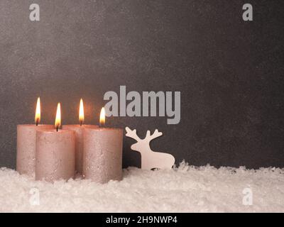 Quarta candela dell'Avvento brucia, sfondo di pietra scura con spazio per il testo o l'immagine Foto Stock