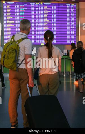 Coppia irriconoscibile che soggiornano all'aeroporto. Vista posteriore dei viaggiatori . Pronto per le vacanze Foto Stock
