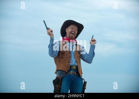 Cercavo occidentale. Buon cowboy divertente con arma. Bandito americano, uomo occidentale con cappello. Ovest e pistole. Foto Stock