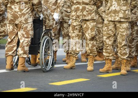 Profondità di campo poco profonda (fuoco selettivo) immagine con soldati veterani dell'esercito rumeno, di cui uno è ferito e disabile, seduto su una sedia a rotelle. Foto Stock