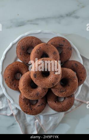 Ciambella glassata al cioccolato con gocce di cioccolato su un tavolo Foto Stock