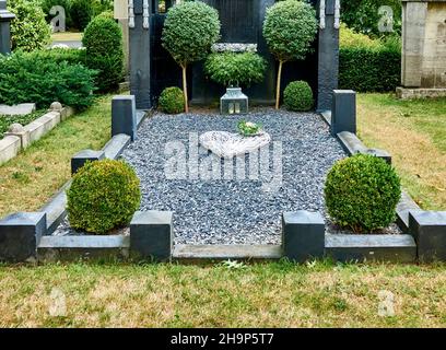 Braunschweig, Germania, 27 agosto 2020: Tomba minimalista semplice e nobilemente progettata con ghiaia e cespugli di buxus nel cimitero principale Foto Stock