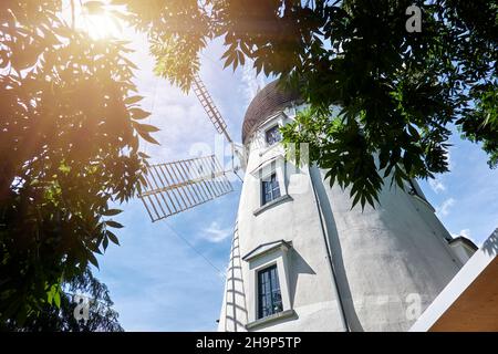 Gifhorn, Germania, 3 agosto 2020: Mulino per matrimoni portoghese bianco nel centro della città di Gifhorn, grandangolo girato retroilluminato Foto Stock