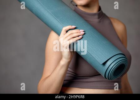 Donna incinta sorridente in abbigliamento sportivo pronto per la ginnastica mattutina o l'esercizio fisico. Giovane donna felice seguire stile di vita sano durante la gravidanza, tenere yoga Foto Stock