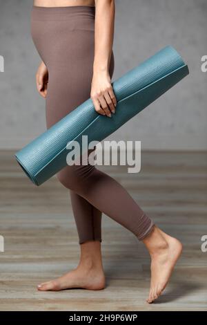 Donna incinta sorridente in abbigliamento sportivo pronto per la ginnastica mattutina o l'esercizio fisico. Giovane donna felice seguire stile di vita sano durante la gravidanza, tenere yoga Foto Stock