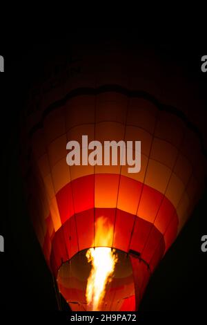 Bruciatore a fuoco con palloncino ad aria calda di notte. Fiamme incandescenti di bruciatore in un pallone ad aria calda. Preparazione per il decollo. Foto Stock