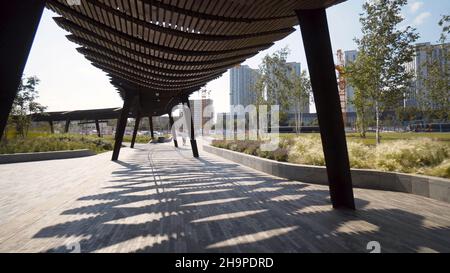 Pergole moderne nel parco in giorno di sole. Azione. Lunghi padiglioni o pergolati nel moderno parco cittadino. Belle soluzioni architettoniche per le aree ricreative i Foto Stock