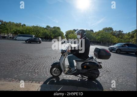 Parigi (Francia): Uomo che guida uno scooter intorno alla rotonda di Etoile, piazza “Place Charles de Gaulle” Foto Stock
