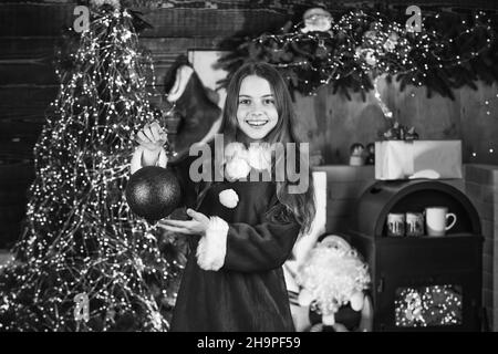 Servizi di noleggio decorazioni. Buona infanzia. La bambina festeggia il natale. Affitto di accessori per le vacanze. Concetto di vacanze invernali. Festeggia il nuovo anno Foto Stock