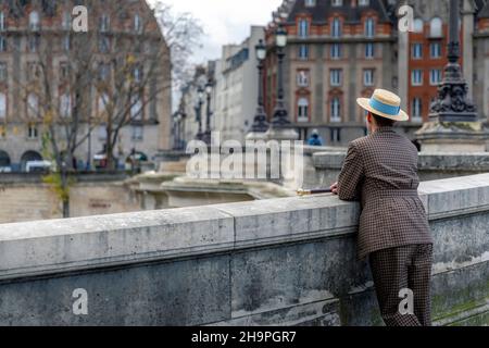 Parigi, Francia - 28 novembre 2021: Un uomo con un cappello, vestito come all'inizio del secolo , cammina per le strade di Parigi Foto Stock