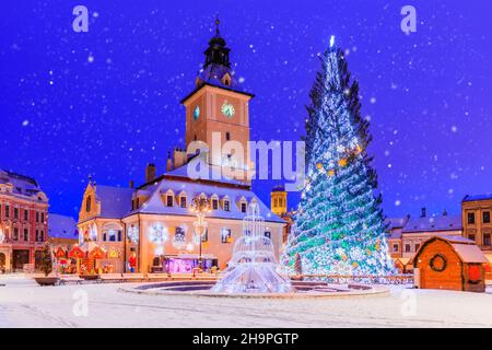 Brasov, Romania. Mercato di Natale della Città Vecchia al crepuscolo con effetto neve. Foto Stock