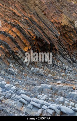 Strati di pietra arenaria sulla spiaggia a Sandymouth, North Cornwall, Regno Unito in una fredda giornata ventosa di novembre Foto Stock