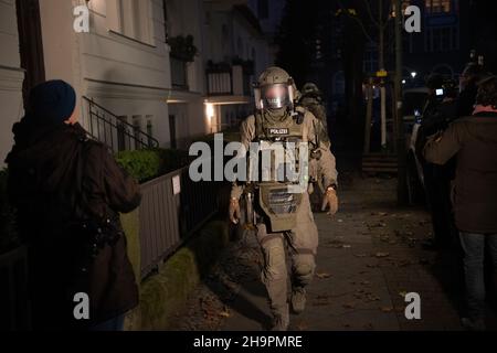 Berlino, Germania. 08th Dic 2021. Forze di emergenza sulla loro strada verso un raid. Dall'inizio di mercoledì mattina, la polizia ha preso provvedimenti a livello nazionale contro una banda sospetta di contrabbando. La polizia federale e le dogane hanno cercato numerosi appartamenti e aziende. Credit: Paul Zinken/dpa - ATTENZIONE: La persona è stata pixellata per motivi legali/dpa/Alamy Live News Foto Stock