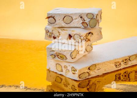 Torrone con mandorle e nocciole su uno sfondo dorato dove si riflette, copia spazio Foto Stock