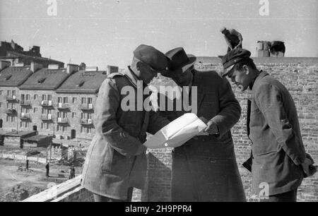 Warszawa, 1949-03. W latach 1948-1949, wraz z budow¹ osiedla mieszkaniowego Mariensztat dla przodowników pracy na Powiœlu, odbudowano w kszta³cie historycznym kamienice przy ulicy Bednarskiej. NZ. Ekipa nadzoru budowlanego w odbudowywanej kamienicy przy pó³nocnej pierzei ulicy Bednarskiej; w g³êbi domy przy ulicy Mariensztat. mta PAP Dok³adny dzieñ wydarzenia nieustalony. Varsavia, marzo 1949. La costruzione di Mariensztat insediamento abitativo per eroi del lavoro socialista nel distretto di Powisle. Gli appartamenti in via Bednarska sono stati costruiti secondo i loro designes pre-WW2. PICT Foto Stock