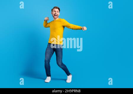 Foto a grandezza naturale del corpo di un ragazzo funky che indossa un elegante abito da ballo che guarda copyspace isolato sfondo di colore blu chiaro Foto Stock