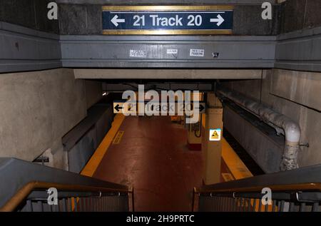 New York City, New York, USA - 21 novembre 2021: Scale che portano a piste vuote 21 e 20 della lunga ferrovia isola a Penn Station a New York City Foto Stock