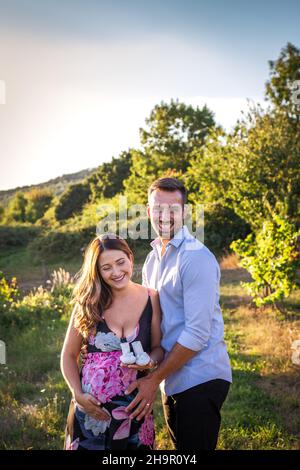 Coppia felice in attesa del bambino. Donna incinta sorridente con il marito Foto Stock