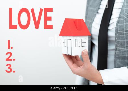 Segno di testo che mostra Amore. Panoramica aziendale sensazione di forte o costante affetto per una persona sentire profondo romantico uomo presentare casa affitto in vestito Foto Stock