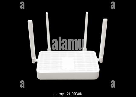 Moderno router WiFi 6 con quattro antenne isolate su sfondo nero. Foto Stock