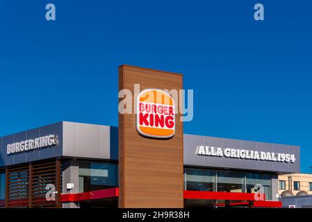 Moncalieri, Torino, Italia - 6 dicembre 2021: Cartello con nuovo logo del Burger King Restaurant su cielo blu con nuvole in via fortunato Postiglione i Foto Stock