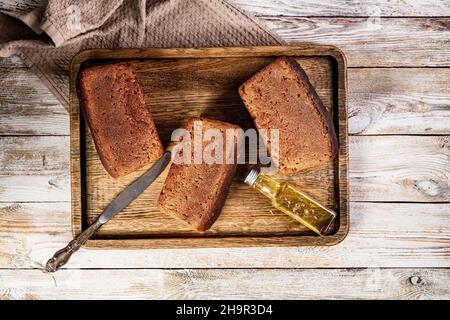 Loafs di pane di segale. Pane fresco fatto in casa a base di farina integrale di segale. Deliziosi dolci tradizionali su un vassoio di legno su sfondo rustico. Sale Foto Stock