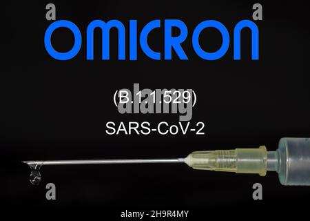 Siringa per iniezione con il vaccino contro il virus Omicron (B.1.1.529), fotografia in studio con sfondo nero Foto Stock
