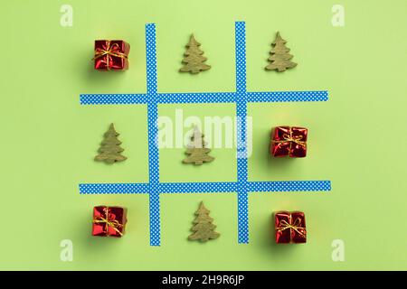 Anno nuovo tic tac toe gioco, isolato su sfondo verde. Natale, concetto d'inverno. Appartamento laico, vista dall'alto. Foto Stock