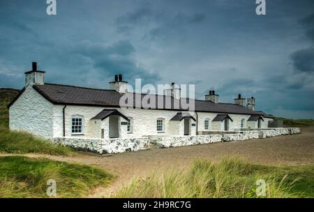 Row of Pilot Cottages sull'isola di Llanddwyn al largo della costa di Anglesey vicino a Newborough Warren North Wales. Fotografato nel mese di settembre Foto Stock