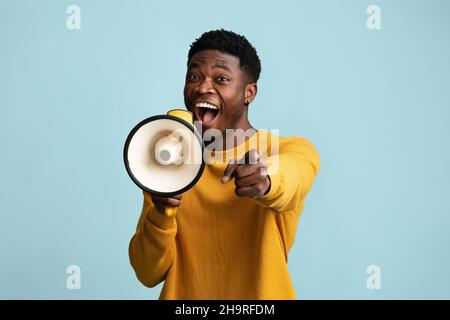 Emotivo ragazzo nero con megaphone fare annuncio Foto Stock
