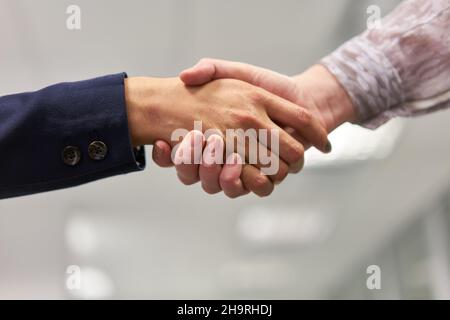 Uomini d'affari a shakehands come simbolo di saluto e cooperazione Foto Stock