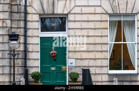 Casa cittadina in stile georgiano dipinta di verde con la corona di Natale, Edimburgo New Town, Scozia, Regno Unito Foto Stock