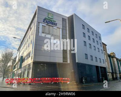 Holiday Inn Express, Dundee, Tayside, Scozia, 8th dicembre 2021: Pictured-Storm barra ha strappato il rivestimento dal lato dell'Holiday inn Express, che ha causato la strada adiacente di essere chiuso per un certo tempo fino a che la valutazione strutturale è stata intrapresa nella misura del danno. Sul marciapiede sottostante sono state erette barriere temporanee. Credit:Barry Nixon/Alamy Live News Foto Stock