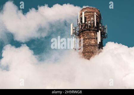 Fumo denso e pesante che esce da un enorme e alto camino chimico fabbrica sotto un cielo blu Foto Stock