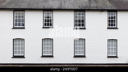 Lato di una vecchia casa con pareti in mattoni bianchi con finestre in legno vittoriano bianco. REGNO UNITO Foto Stock